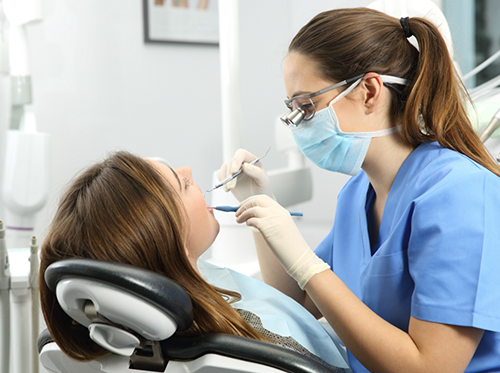 Female dentist in Delray Beach treating patient