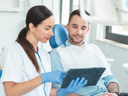 Female dentist showing patient a tablet