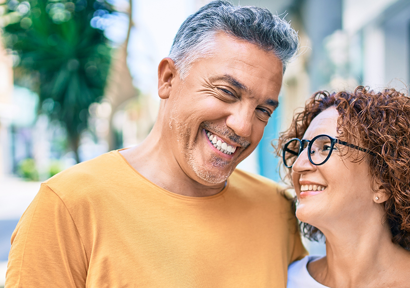 Man and woman smiling at each other outside