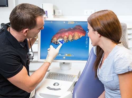 Dentist showing patient digital impression of teeth