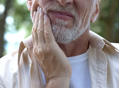 Man with toothache due to dental emergency in Delray Beach