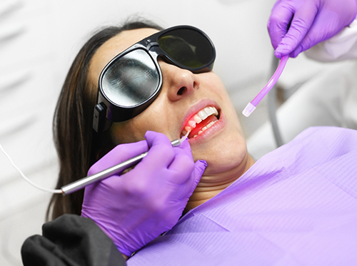 Woman receiving laser treatment in dental chair