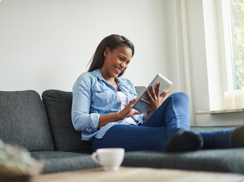 Woman sitting on couch looking at tablet