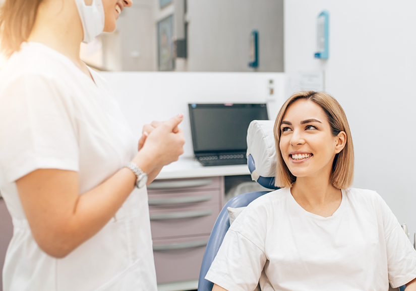 Dentist talking to a female dental patient