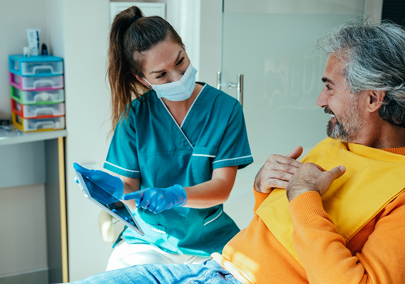 Smiling dental patient talking to female dentist