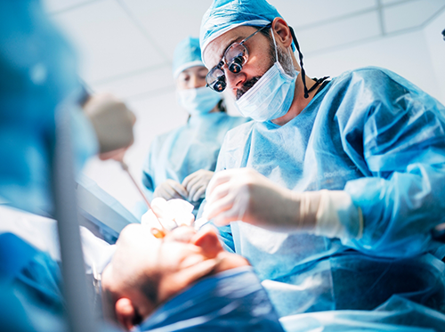 Dentist with surgical mask performing a wisdom tooth extraction